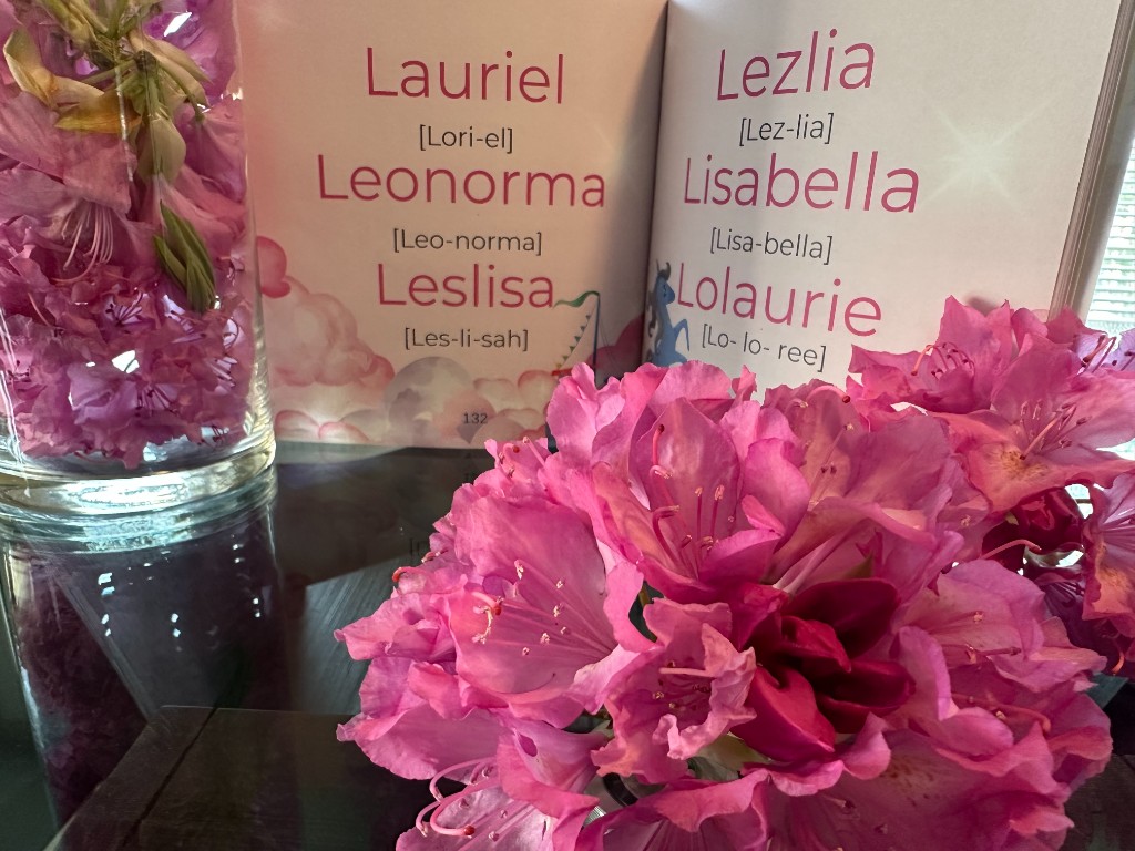 Open pages of This is it! showing baby names with pronunciations in pink typography